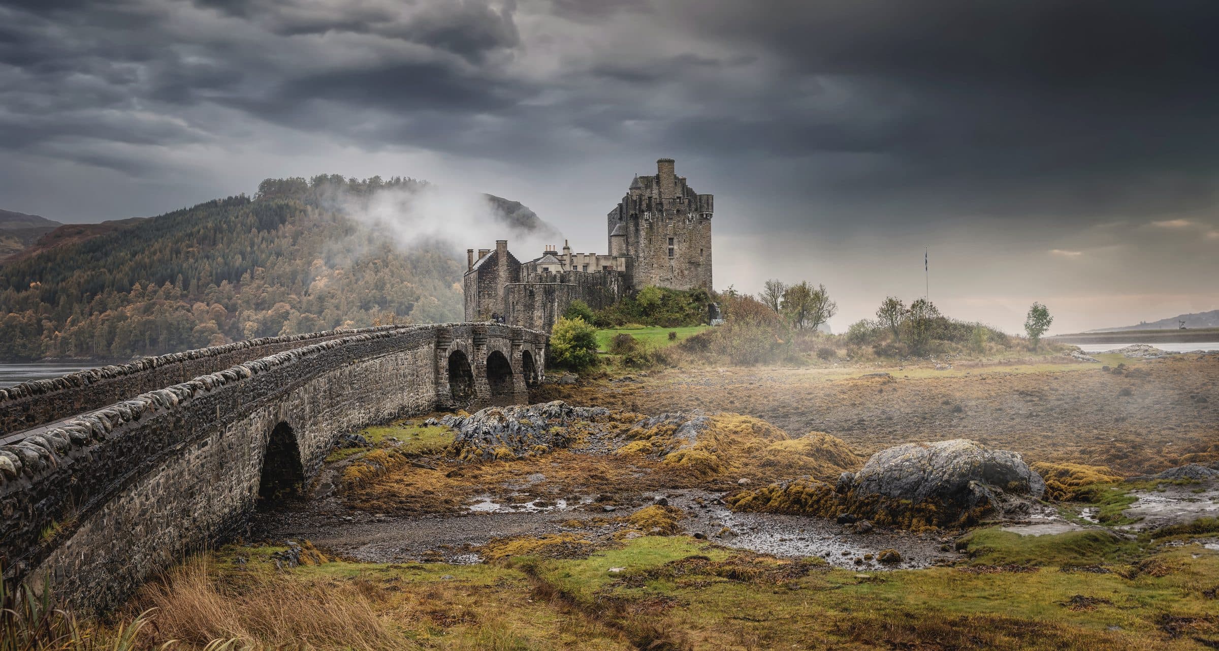 Eilean Donan castle and its stone bridge in autumn mist
