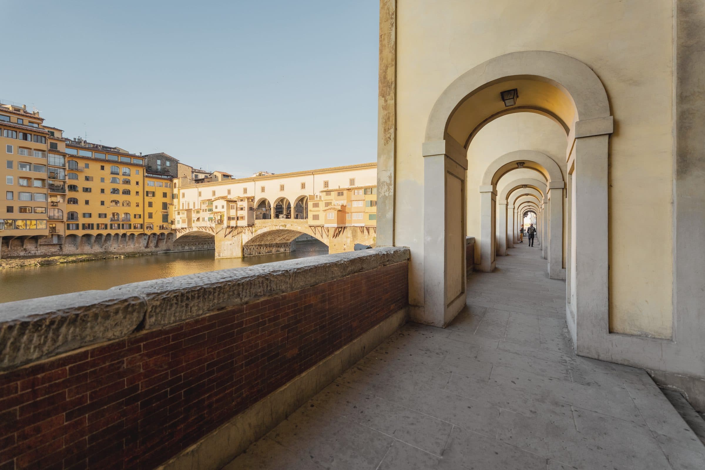 The Ponte Vecchio seen from a riverside arcade in Florence, early morning