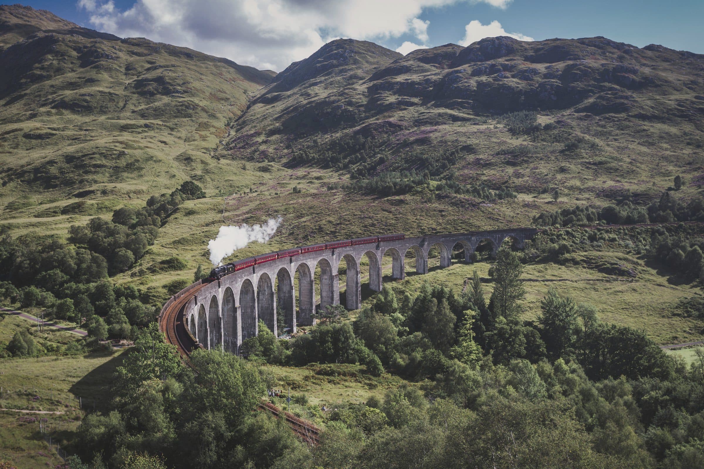 The Glenfinnan Viaduct in the West Highlands, a steam train crossing above the glen