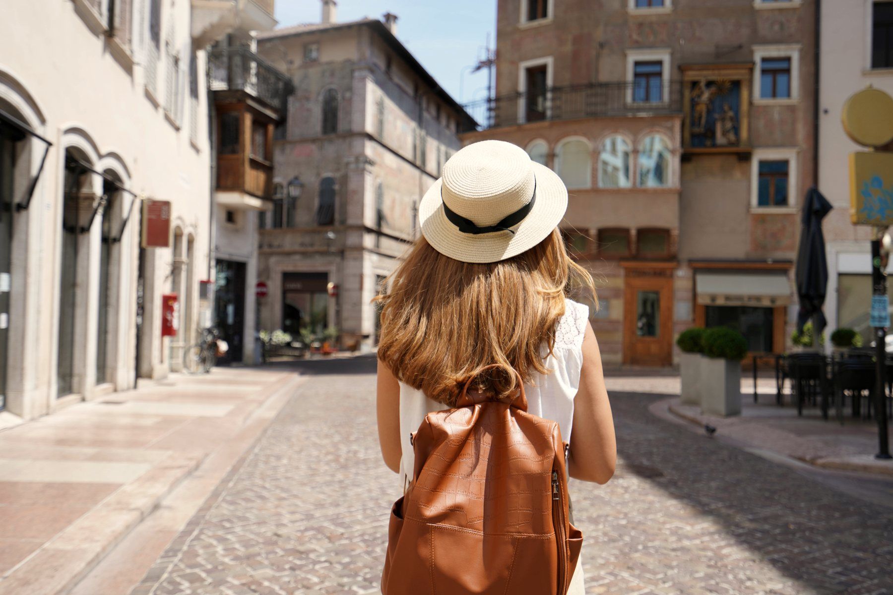 A traveler with a backpack walks into an old European street.